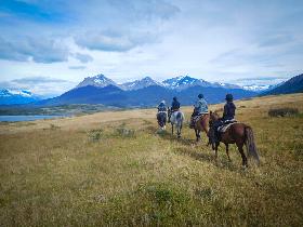a group of four people horse riding throughout the Argentinian mountains